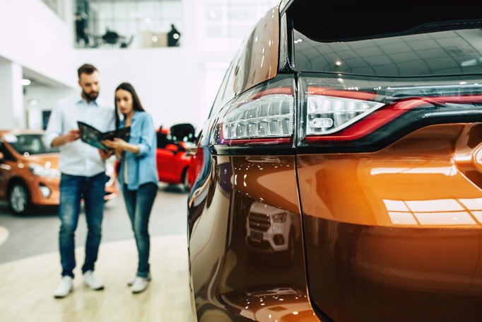 Car buyers looking at car brochure