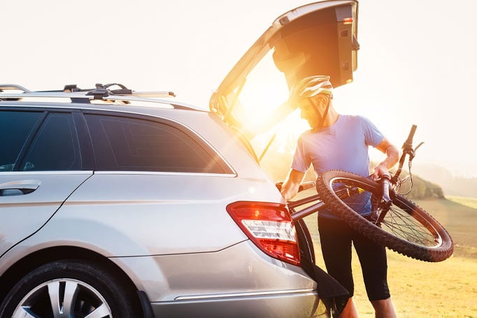 Man putting bike in trunk of the car