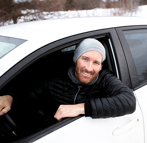 Man smiling and looking out car window