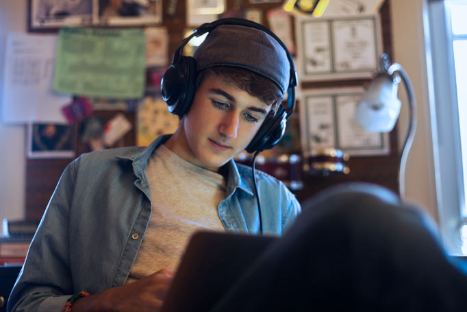 Young man wearing headphones and looking at his tablet