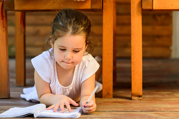 Little girl writing in a notebook