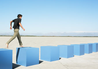 Man walking carefully on giant blocks